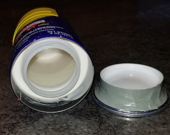May include: An empty blue and yellow can with a white plastic lid. The can has the text "WAY'S" and "EXTREME" on it. The lid is open and the inside of the can is visible. The can is sitting on a dark surface.