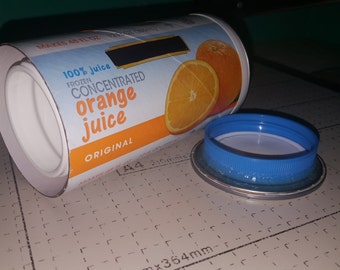 May include: A white cardboard container with a blue lid. The container is labeled "100% Juice Frozen Concentrated Orange Juice Original". The container has a picture of an orange slice on it.
