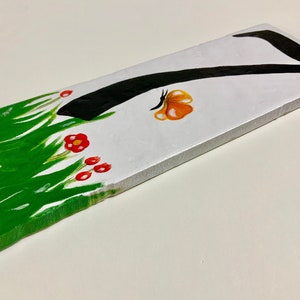 Peut inclure: Une pancarte en bois blanc avec un numéro sept peint en noir, un motif d'herbe peint en vert et un papillon peint en rouge et orange.