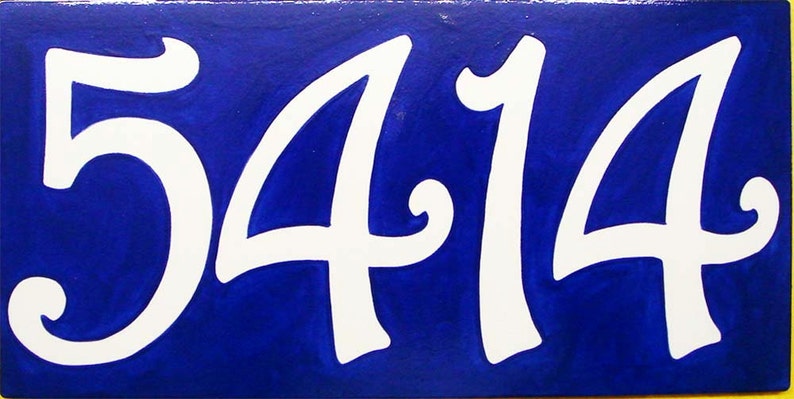 May include: White ceramic tile with the number 5414 painted in a white cursive font on a royal blue background.