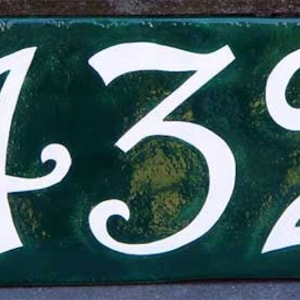 May include: A green ceramic house number plaque with white numbers that read "432".