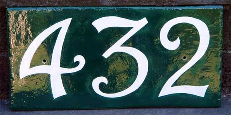May include: A green ceramic house number plaque with white numbers that read "432".