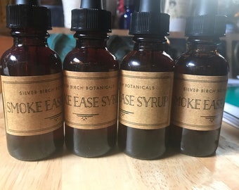 May include: Four brown glass bottles with dropper tops and brown paper labels. The labels read "Smoke Ease Syrup" and "Silver Birch Botanicals".