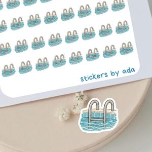 May include: A white sticker sheet featuring a repeating pattern of small swimming pool illustrations with blue water and silver ladders. The text stickers by ada is printed in blue in the bottom right corner. A single matching pool sticker is below.