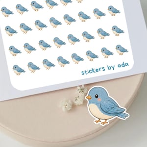 May include: A rectangular sheet of stickers featuring rows of small, light blue birds with orange beaks and white bellies. The text "stickers by ada" is printed in blue in the bottom right corner. A single, larger matching bird sticker is placed below.
