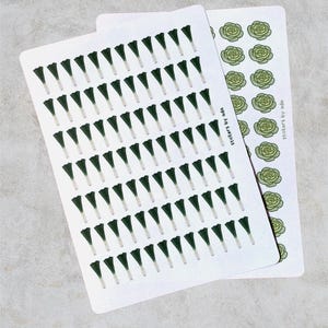 Example of how the sheets look like: Two sticker sheets with botanical designs. One sheet shows many dark green, leek illustrations with white stems. The second sheet features light green lettuce illustrations. The text "stickers by ada" is printed on the sheets.
