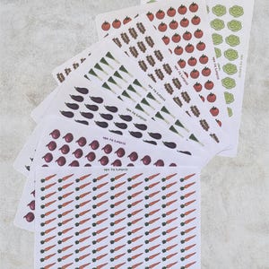 May include: A collection of seven rectangular sticker sheets featuring various vegetable illustrations including carrots, red onions, eggplants, green onions, skewers, tomatoes, and lettuce. Each sheet displays the text stickers by ada.