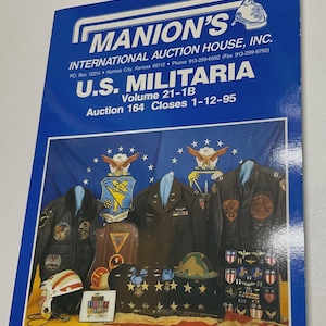 May include: A blue auction catalog titled Manion's International Auction House, Inc. U.S. Militaria Volume 21-1B Auction 164 Closes 1-12-95. The cover features military jackets, patches, a helmet, and medals against a blue flag background.