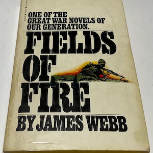 May include: A vintage paperback book titled "Fields of Fire" by James Webb. The cover features bold black text and an illustration of a soldier. The book is a Bantam Book and is described as one of the great war novels of our generation.