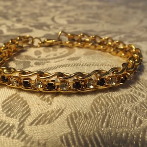 Vintage gold tone bracelet with sparkling black and clear rhinestones.Mint condition. 8&quot; length.  Clean. Gift idea.