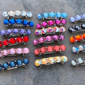 May include: A set of 20 hair clips with different colored crystal embellishments. Each clip has five crystals in a row.