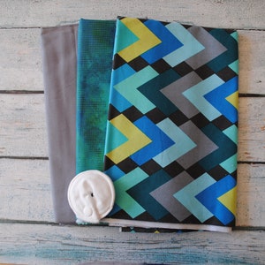 May include: Three fabric swatches in gray, green and blue with a geometric pattern. A white button is included.