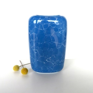 May include: A blue ceramic vase with a crackled glaze finish. The vase has a rectangular shape with rounded edges.
