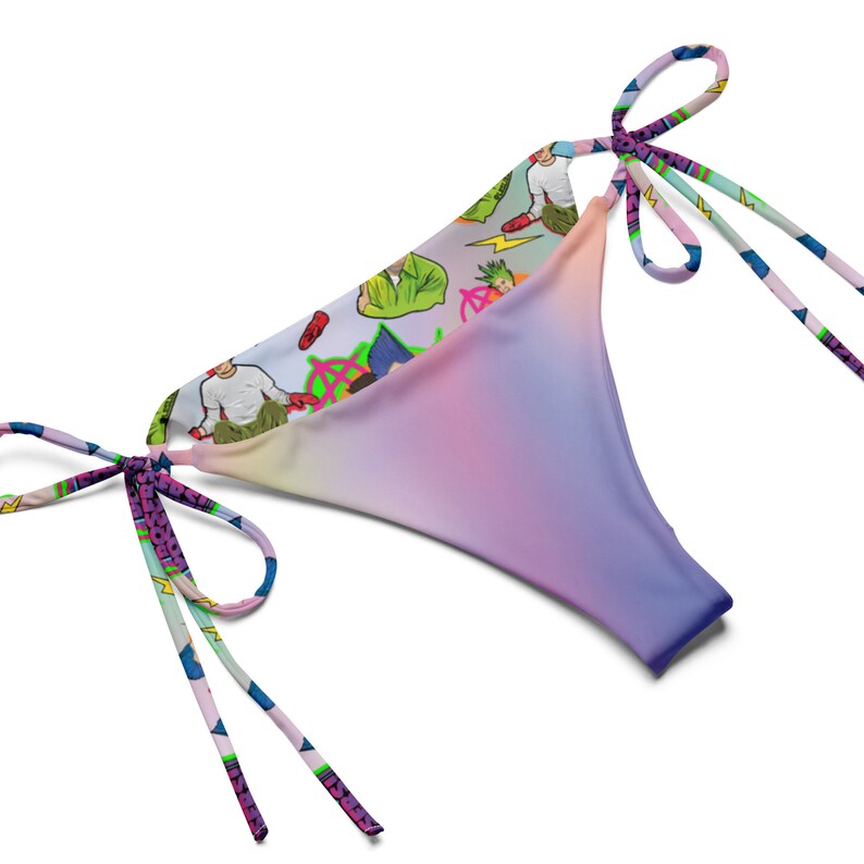 May include: A colourful bikini bottom with a tie-side design. The fabric features a gradient pattern in shades of pink, purple, and blue. The other side of the bikini bottom has a white background with a colourful cartoon print.