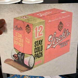 May include: A vintage illustration of a 12-can pack of Stroh's Bohemian Style Beer. The pack is pink and gold with the Stroh's logo and the text "12 Can Stay Cold Pack". A single can is rolling out of the pack, with the Stroh's logo visible on the can.