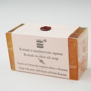Könnte beinhalten: Eine Seife aus Olivenöl mit einem Etikett, auf dem steht "Kornati u maslinovom sapunu Kornati in olive oil soap Sapun od čistog ulja majčine dušice s Kornata Soap with pure wild thyme oil from Kornati".
