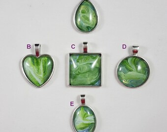 May include: Five different pendants with green and white marbled designs. The pendants are in the shapes of a teardrop, heart, square, circle, and oval. Each pendant has a silver bail.
