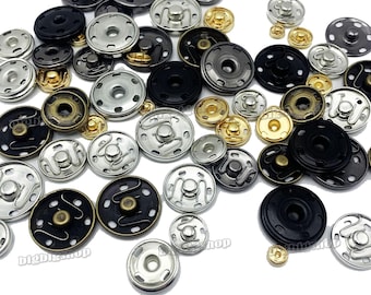 Puede incluir: Surtido de botones a presión de metal en varios colores y acabados, incluyendo plata, oro, negro y bronce. Los botones tienen diferentes diseños, incluyendo liso, texturado y estampado.