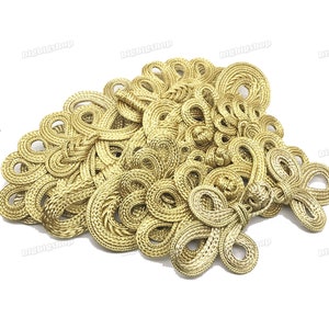 May include: A collection of gold Chinese knot embellishments, also known as lucky knots, in a variety of intricate designs. These decorative knots are often used for clothing, accessories, and home decor.