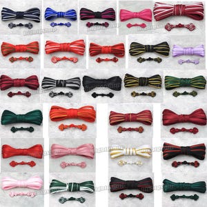 Puede incluir: Surtido de 20 cintas de diferentes colores con cierres de botón a juego. La cinta está doblada por la mitad para crear una forma de lazo. Los botones son de varias formas y tamaños.