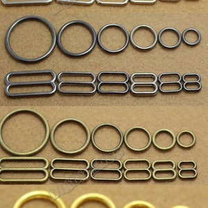 Puede incluir: Surtido de anillos y anillos en D de metal en acabados plateado, negro, bronce y dorado. Los anillos son de varios tamaños y son ideales para manualidades, elaboración de joyas y otros proyectos de bricolaje.