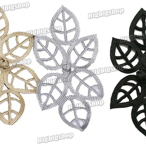 May include: Three leaf-shaped decorative embellishments in gold, silver, and black. Each leaf cluster features a detailed, openwork design with visible veins. The embellishments are likely for crafts or sewing projects.