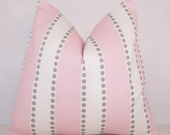 May include: A pink and white pillow with gray polka dots. The pillow has a striped pattern with alternating pink and white stripes.