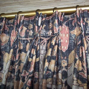 May include: Close-up of a set of curtains with a dark blue background and a floral pattern in shades of red, brown, and beige. The curtains are hung on a gold rod with decorative finials.