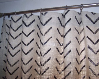 May include: White curtains with a black chevron pattern. The curtains are hung on a silver curtain rod.