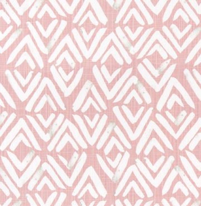 May include: Pink and white geometric pattern fabric. The design features white chevron shapes arranged in a repeating pattern on a pink background. The fabric has a textured appearance.