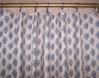 May include: White curtains with a blue floral pattern. The curtains are hung on a gold rod with silver hooks.