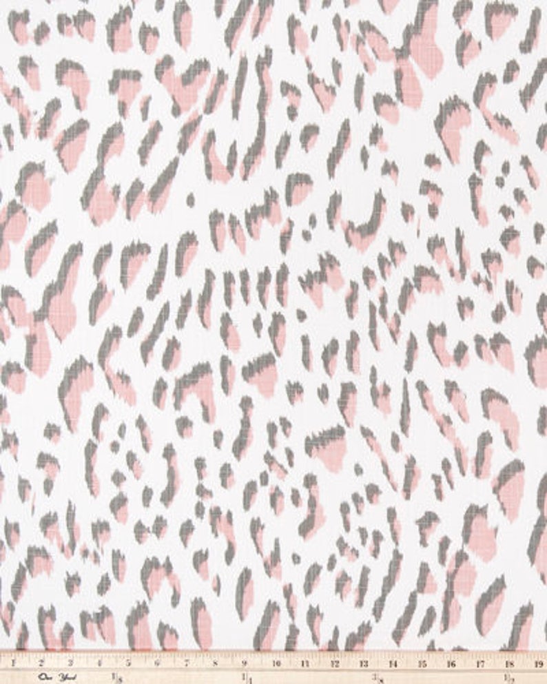 May include: White fabric with a pink and gray leopard print design. The pattern features irregular shapes in pink and gray, scattered across a white background. The fabric is measured in inches.