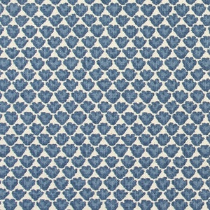 May include: Blue and white fabric with a repeating pattern of stylized flower shapes. The fabric is measured with a ruler in inches.