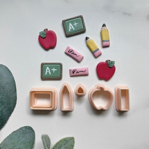 Juego de cortadores de arcilla polimérica con temática escolar: manzana, lápiz y pizarra.