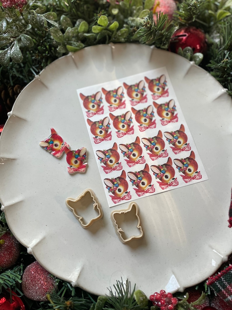 May include: A white plate with a sheet of 16 vintage Christmas deer stickers, two deer cookie cutters, and two hand-painted deer ornaments.