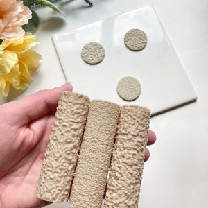Peut inclure: Trois rouleaux texturés beiges pour l'artisanat et la décoration. Les rouleaux sont faits d'un matériau souple et pliable et ont une surface texturée en relief.