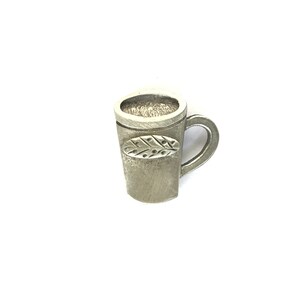 May include: A silver metal mug with a leaf design. The mug is approximately 5 cm tall.