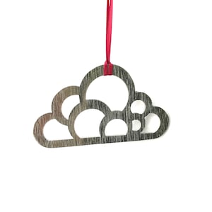 May include: A silver metal cloud-shaped ornament with a red ribbon attached. The cloud has a cutout design with multiple circles.