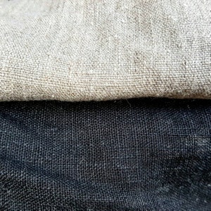 May include: Two pieces of fabric, one beige and one black, are woven with a textured pattern. The beige fabric is folded over the black fabric.