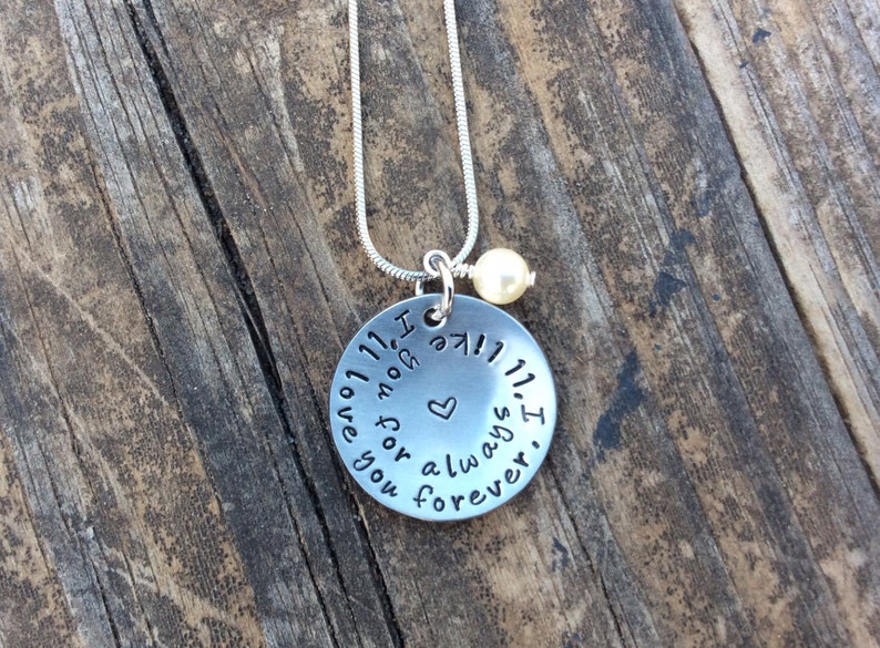 May include: Silver necklace with a round pendant that reads "I love you forever and always. I" with a small heart in the center. The necklace has a small pearl charm.