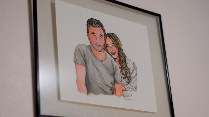 May include: A framed illustration of a couple, a man and a woman, smiling and looking at each other. The man is wearing a gray shirt and the woman is wearing a white shirt with a fur collar.