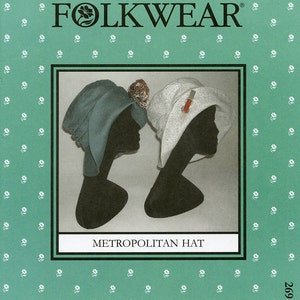 May include: A Folkwear pattern cover featuring two Metropolitan Hats on black mannequin heads. One hat is teal, the other is white with a red and gold pin. The background is teal with a white floral pattern. The text "FOLKWEAR" and "METROPOLITAN HAT" are visible.