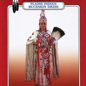 May include: A sewing pattern for a Plains Indian buckskin dress. The pattern is from Missouri River Patterns Brand. The pattern shows a woman wearing a white buckskin dress with red and blue beadwork, a white feather headdress, and a white feather fan.