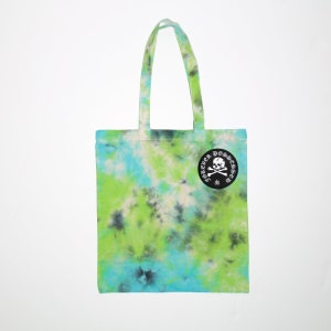 May include: A green, blue, and white tie-dye tote bag with a black circle patch that says "Forever Possessed" with a skull and crossbones in white.