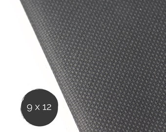 May include: A dark gray fabric with a visible woven grid texture. A circular black icon in the lower left corner displays the white text 9 x 12, indicating the dimensions of the material in inches. The fabric features a consistent pattern.