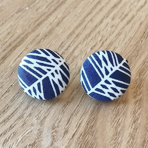 May include: A pair of blue and white fabric earrings with a geometric pattern.