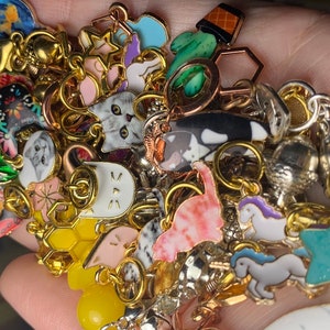 A completely random assortment of colorful  metal, enamel, and acrylic stitch markers in a hand