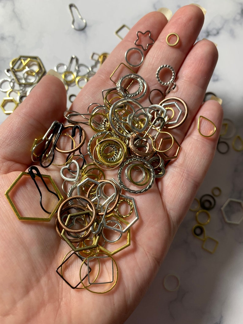May include: A variety of gold, silver, and copper-toned metal rings, circles, and geometric shapes. The shapes include hexagons, stars, and squares.