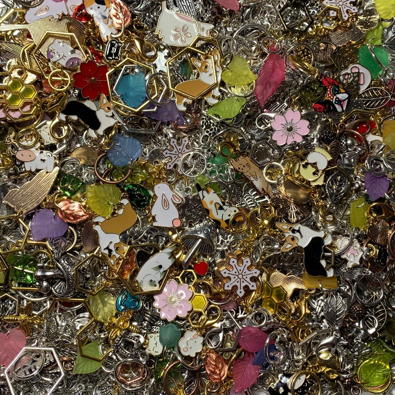 May include: A large collection of colorful charms and pendants, including animal shapes, flowers, snowflakes, and geometric designs. The charms are made of metal and have a variety of finishes, including silver, gold, and copper.