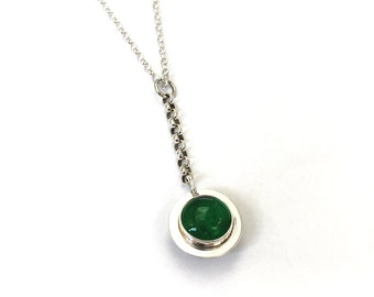 May include: A silver chain necklace with a pendant featuring a round green gemstone set in a silver bezel.